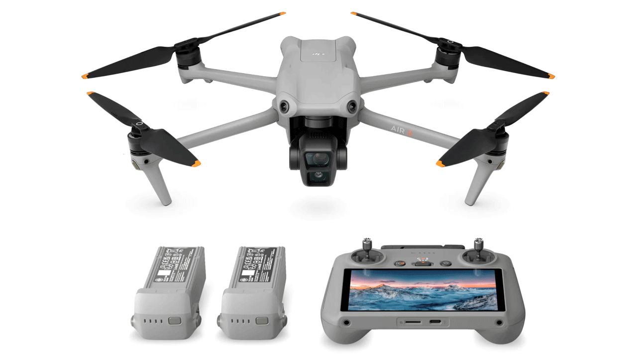 Белый квадрокоптер DJI Air 3 с четырьмя пропеллерами и камерой, показанный с двумя аккумуляторными батареями и пультом дистанционного управления с встроенным экраном
