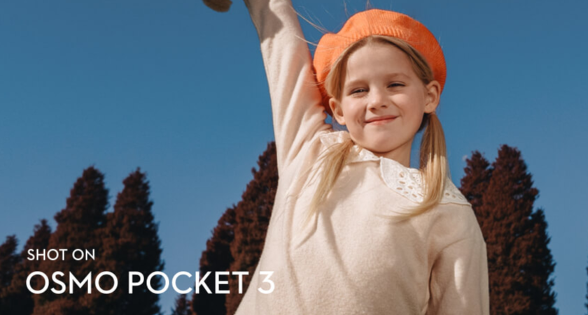 Фото, снятое на DJI Osmo Pocket 3: девочка поднимает руку на фоне голубого неба.