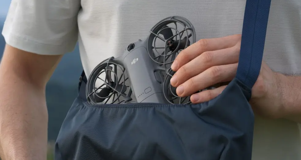Компактный дрон DJI Neo 2, который человек убирает в небольшую плечевую сумку
